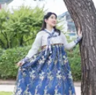 Sujin outdoors in a blue dress