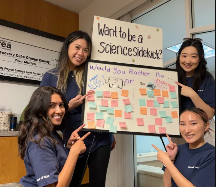 Sujin with teammates holding a workshop sign