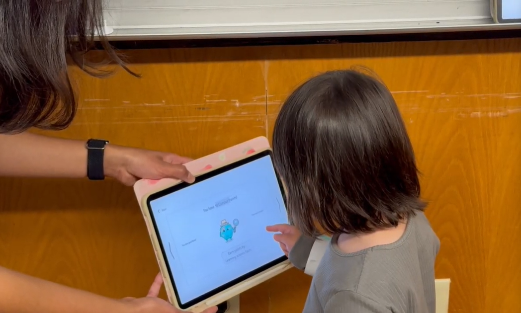 Child and adult using a tablet during play testing